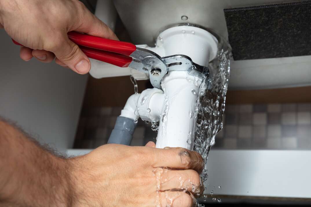 A plumbing repair in progress beneath a sink